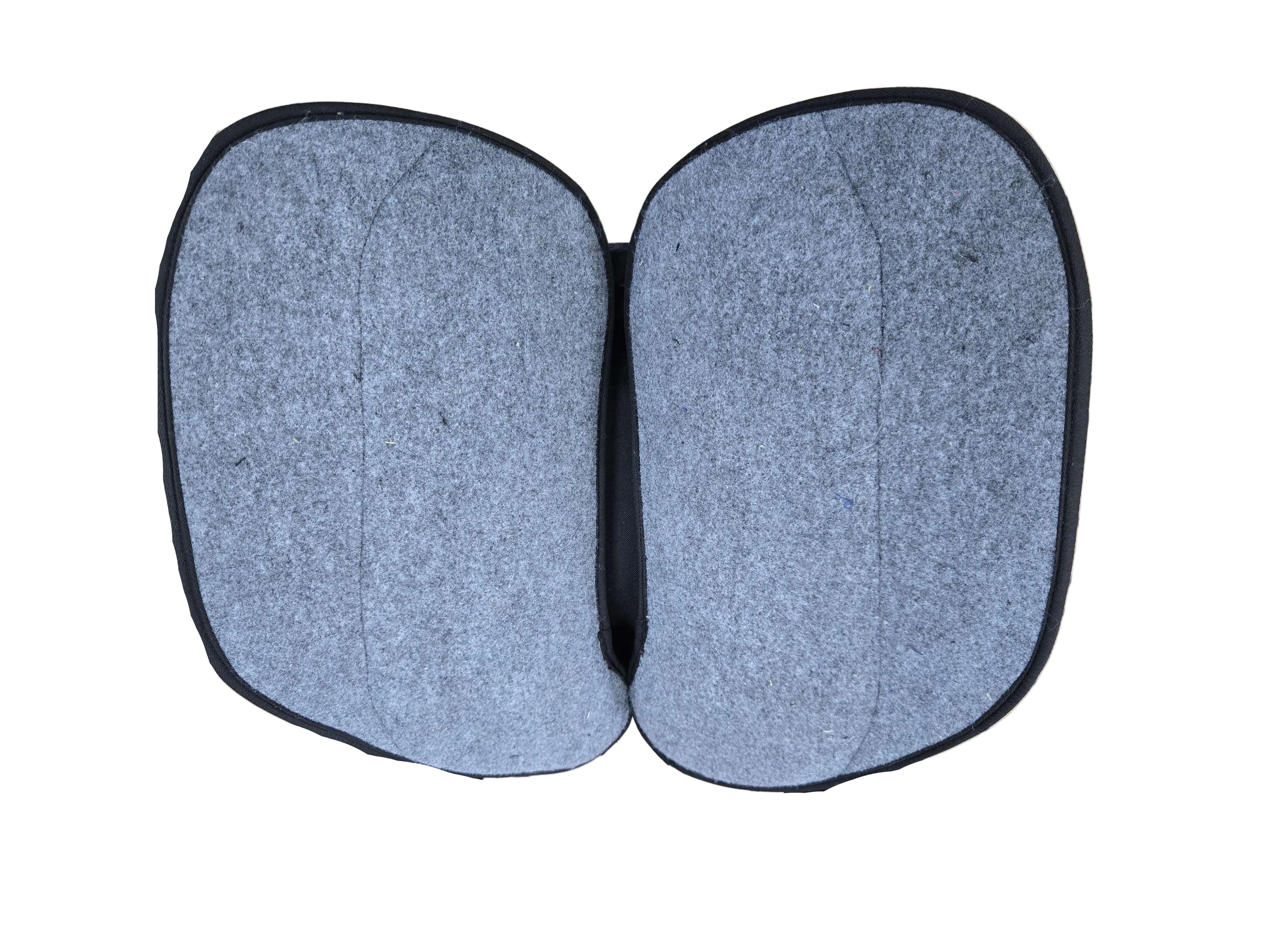 A pair of gray felt motorcycle saddle covers with black trim, laid flat on a tiled floor next to a brown motorcycle.